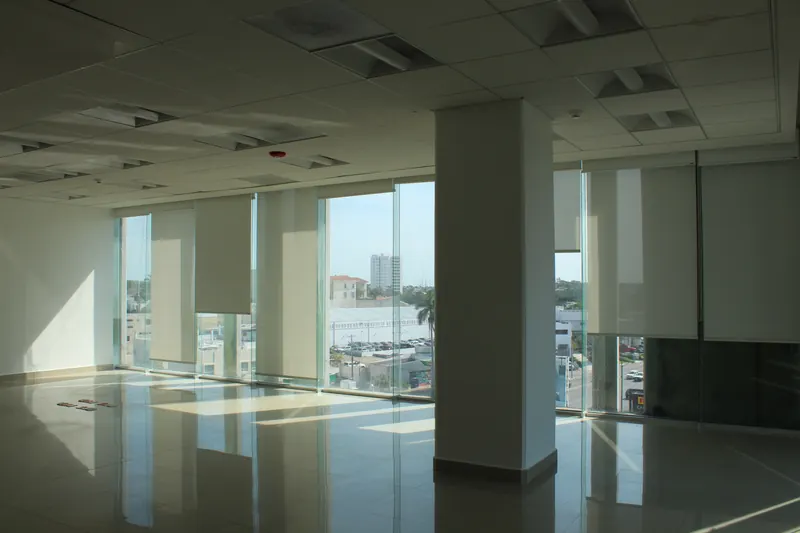 Planta de oficina diáfana con ventanal corrido y vista a la ciudad